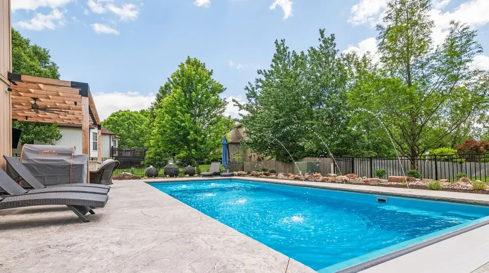 A finished inground pool and patio on a real client property, representing a job won from an owned, exclusive campaign.