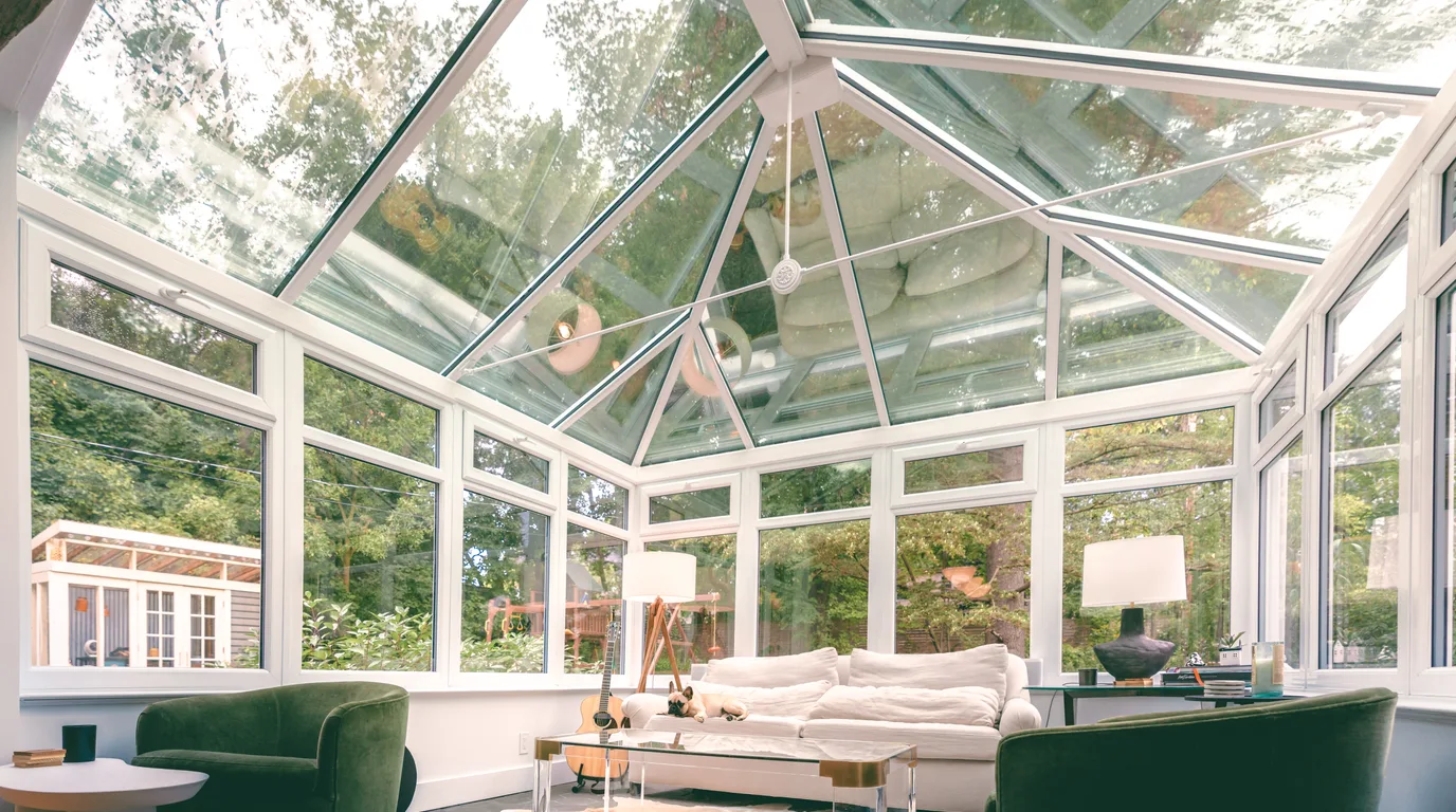 The bright interior of a finished glass conservatory sunroom, representing the high-ticket outdoor-living job at stake when a lead goes unworked.