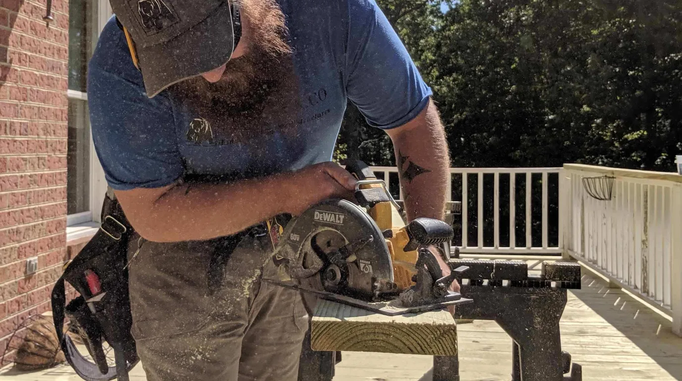 A contractor cutting deck boards on site, mid-build