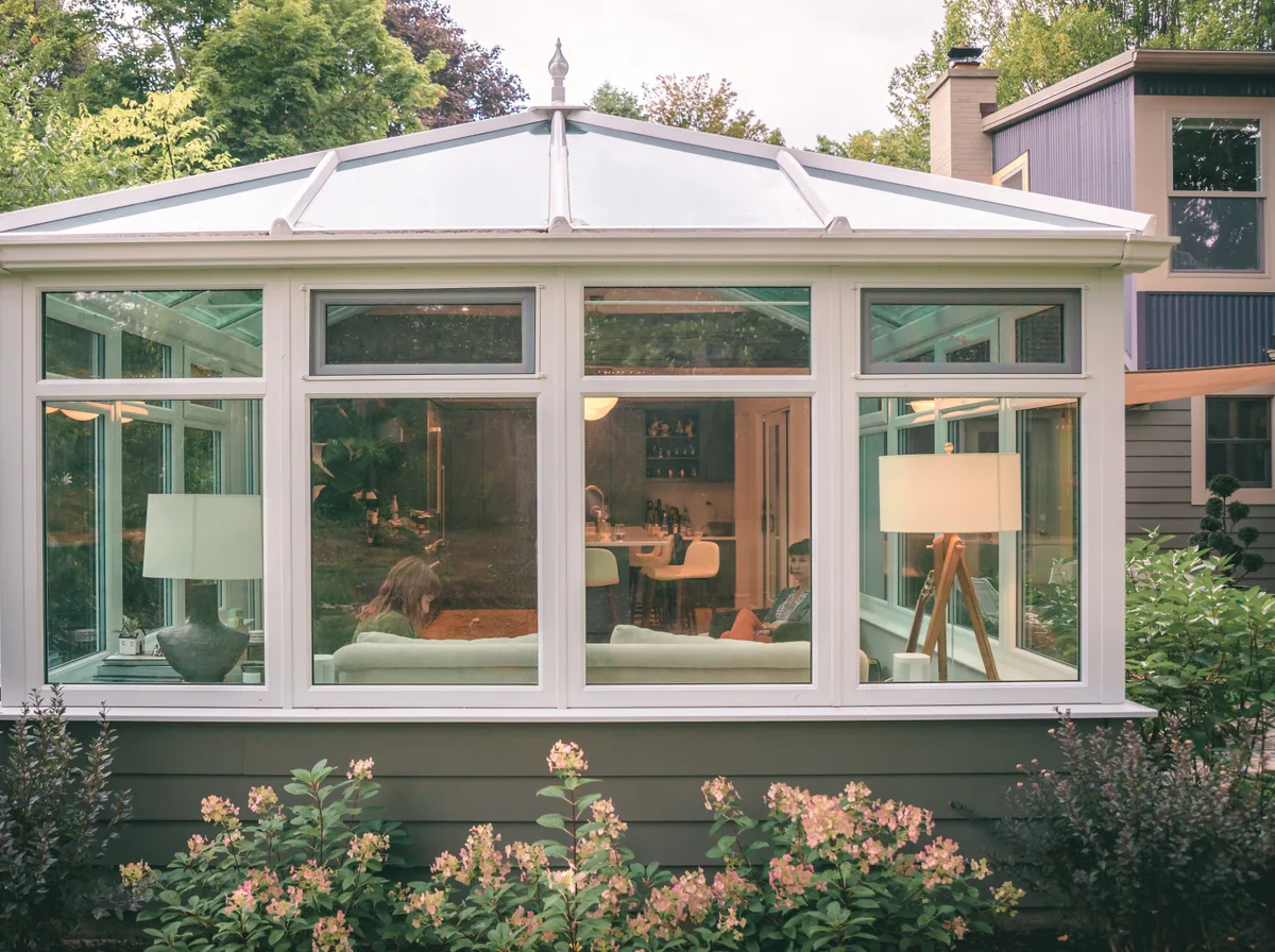A clean four-season sunroom addition on a well-kept home, bright natural daylight