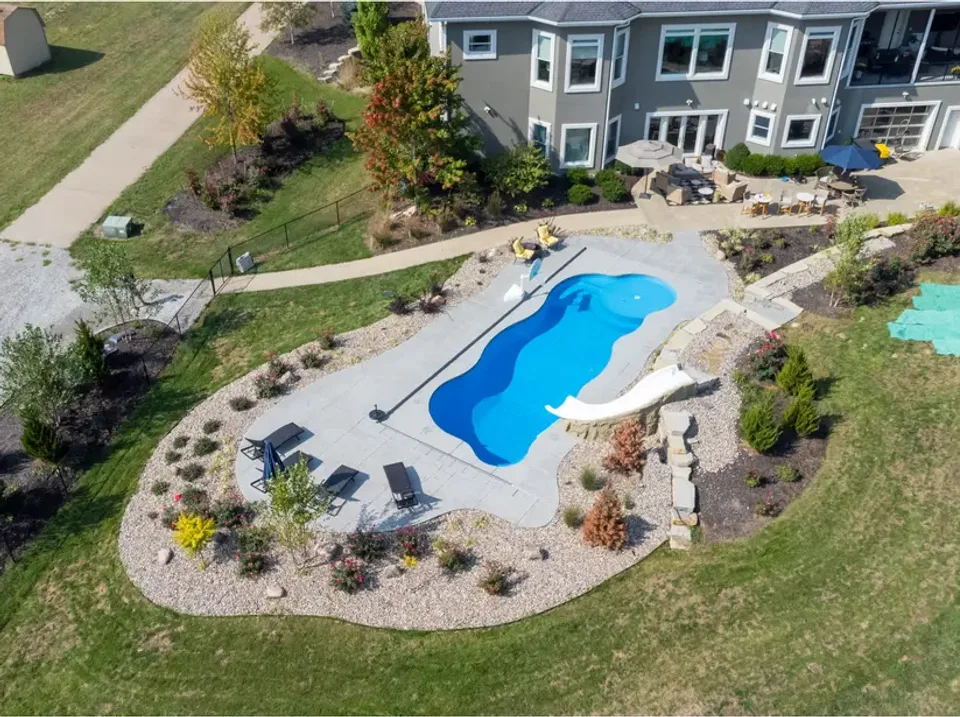 A social post showing a finished freeform pool and slide from above