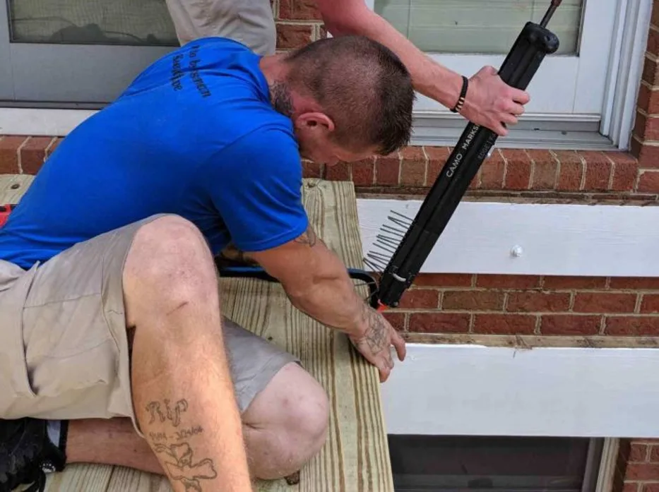 A social post featuring a crew member fastening deck boards on site
