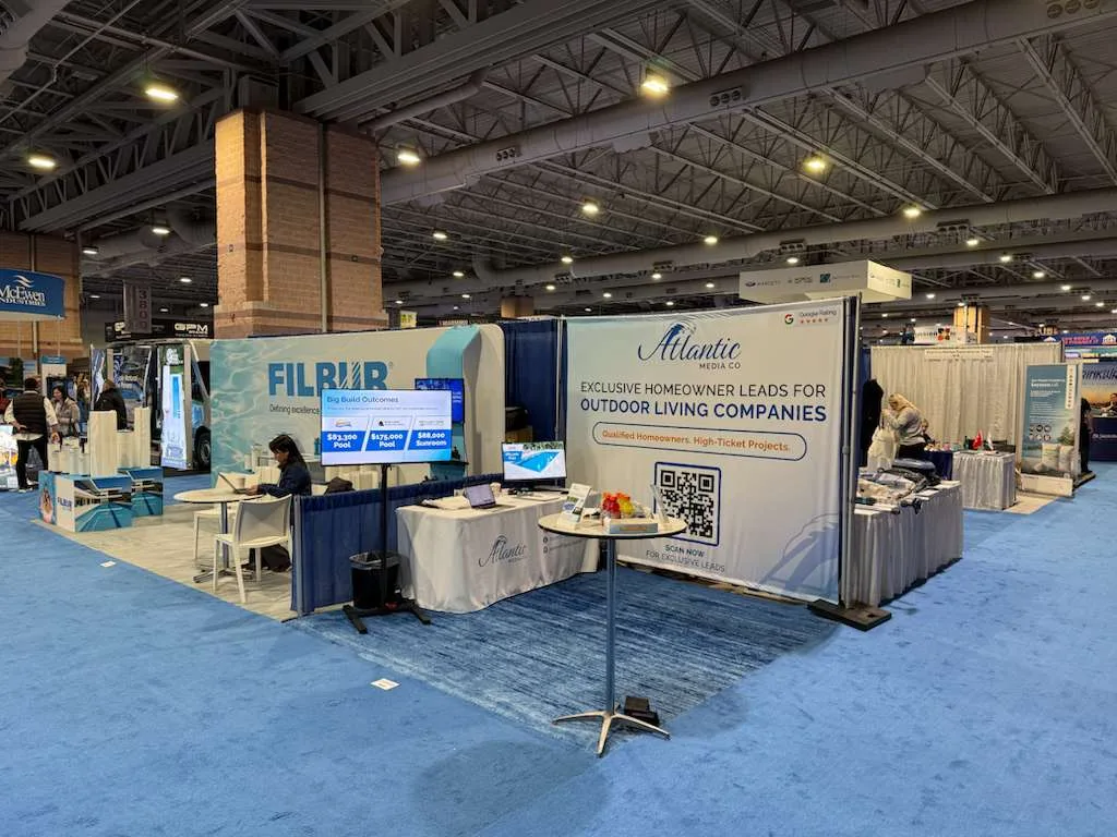 Atlantic Media Company's booth at an industry trade show, with its branded pull-up banner and display table